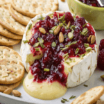 Baked brie with cranberry sauce served with crackers for a festive holiday appetizer