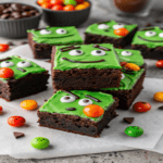 Frankenstein’s Monster Brownies with green frosting, candy eyes, and chocolate faces