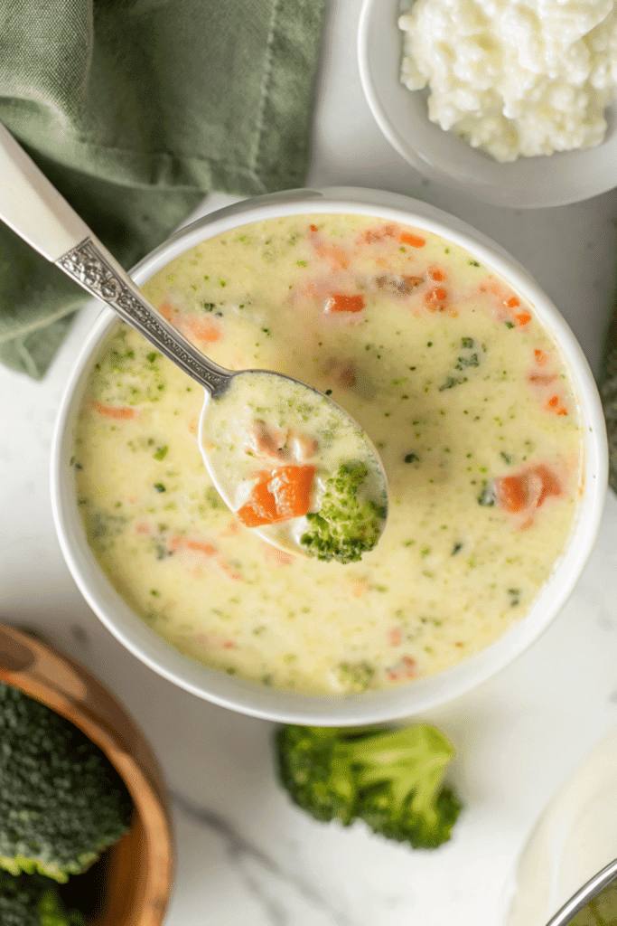 Bowl of High Protein Broccoli Cheddar Soup with spoonful of broccoli and carrots