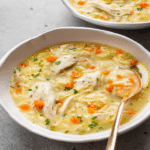 lemon chicken orzo soup served in a white bowl