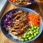 A vibrant bowl of 15-Minute Teriyaki Chicken Bowls with rice, chicken, shredded carrots, edamame, and red cabbage.