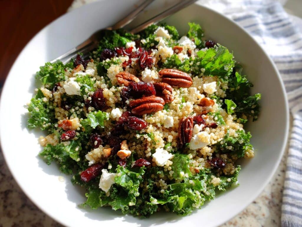 A vibrant bowl of Cranberry Pecan Quinoa Salad with kale, quinoa, dried cranberries, pecans, and feta cheese.