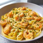 A close-up of delicious Garlic Butter Shrimp Pasta, featuring fettuccine noodles, plump shrimp, and fresh parsley.
