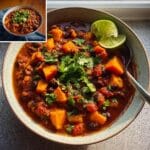 A bowl of hearty Low-Calorie Sweet Potato & Black Bean Chili topped with fresh cilantro and lime wedges.