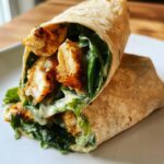 Close-up of a delicious Air Fryer Chicken Caesar Wrap filled with crispy chicken, lettuce, and creamy Caesar dressing.