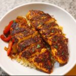 Close-up of sliced Air Fryer Chicken Fajita Bowls with rice, peppers, and onions, garnished with parsley.