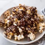 A close-up of fluffy popcorn generously covered in dark chocolate drizzle and sea salt, our Chocolate Drizzled Popcorn.