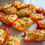 Close-up of baked Freezer-Friendly Stuffed Mini Peppers, featuring a creamy, cheesy topping.