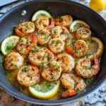 A close-up of a Keto Lemon Garlic Shrimp Skillet, featuring plump shrimp cooked in a buttery lemon and garlic sauce, garnished with fresh parsley and lemon slices.