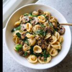 Close-up of a white bowl filled with Turkey & Spinach Protein Pasta Bowls featuring orecchiette pasta, ground turkey, and sautéed mushrooms.