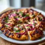Close-up of a freshly baked BBQ Chicken Pizza with Red Onions & Cilantro, sliced and ready to eat.