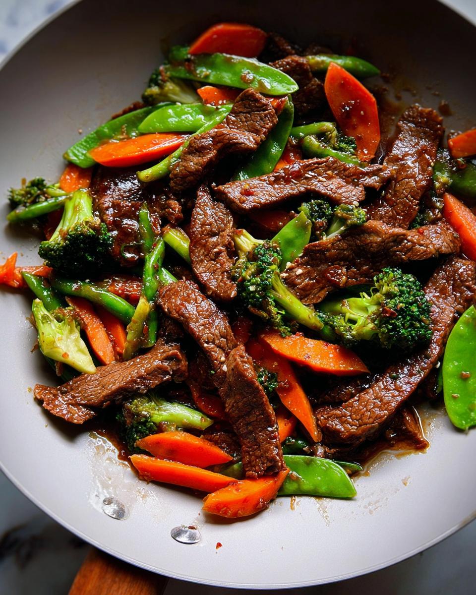 Close-up of Beef & Veggie Stir-Fry with soy-garlic sauce, featuring sliced beef, carrots, broccoli, and snow peas.