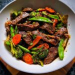 Close-up of Beef & Veggie Stir-Fry with tender beef strips, broccoli, carrots, and snow peas coated in soy-garlic sauce.
