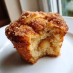 Close-up of a Thermomix Apple Cinnamon Muffin, bitten, showing soft interior and cinnamon sugar crust.