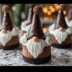 A close-up of a festive Chocolate Gnome Cheesecake featuring a chocolate hat and piped white frosting beard.