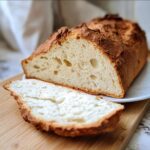 Close-up of a freshly baked Gluten-Free Italian Bread Recipe loaf, sliced open to show the soft, airy interior.