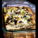 A freshly baked Keto Breakfast Casserole with Mushrooms & Cheese showing a thick, fluffy interior in a glass baking dish.