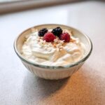 A creamy Keto Breakfast Yogurt Bowl topped with fresh raspberries, blackberries, and toasted coconut flakes.