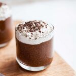 A glass of rich Keto Chocolate Chia Seed Pudding topped with whipped cream and chocolate shavings.
