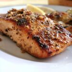 Close-up of a perfectly cooked Lemon Garlic Salmon fillet with a savory, browned crust and seasoning.