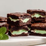 Stack of rich chocolate Mint Chocolate Aero-Style Brownies featuring a thick, light green mint filling.