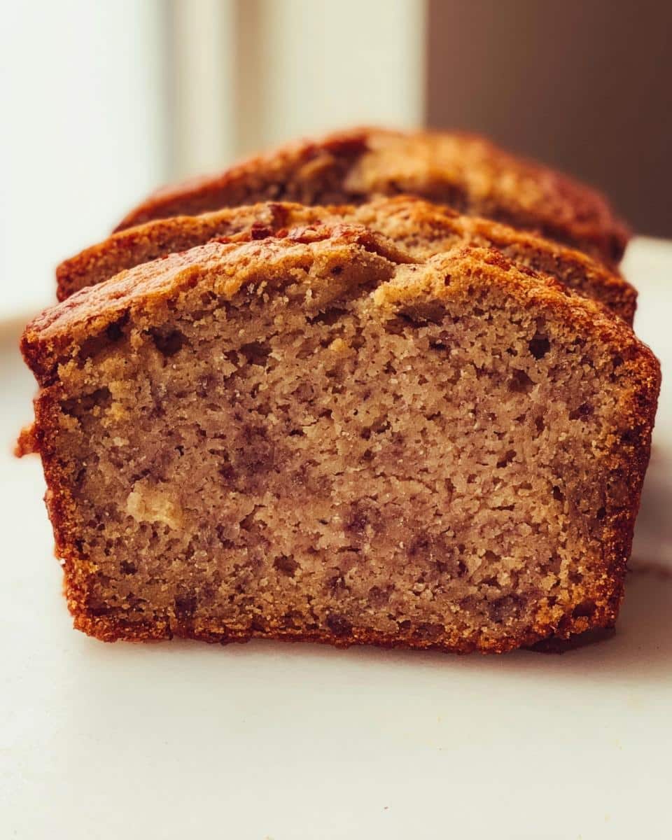 Close-up of moist, sliced Vegan Banana Bread Without Eggs showing a tender crumb texture.