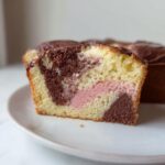 Cross-section of a Moist Thermomix Marble Cake showing yellow, chocolate, and pink marbled batter with chocolate glaze.