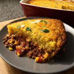 A hearty slice of One-Pan Beef & Cornbread Casserole showing the savory beef filling and golden cornbread topping.