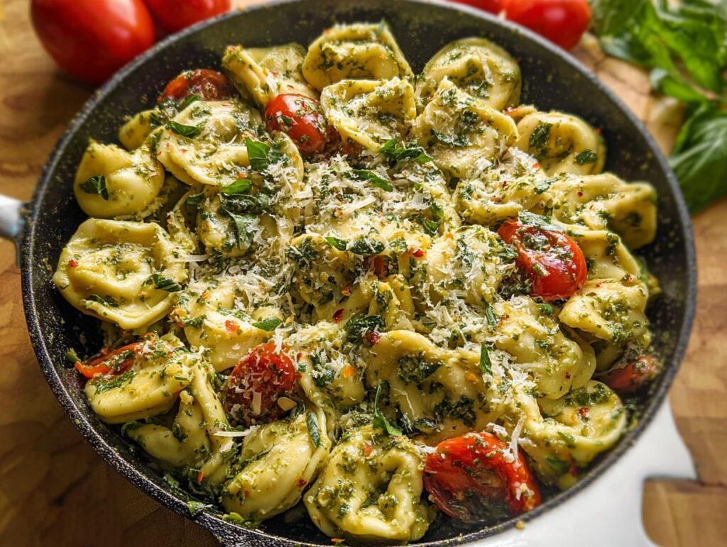Close-up of One-Pot Pesto Tortellini with Cherry Tomatoes, tossed in pesto sauce and topped with Parmesan cheese.