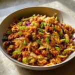 Close-up of a bowl filled with savory Egg Roll in a Bowl mixture, featuring ground meat, cabbage, and green onions.