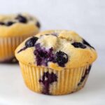 Close-up of a freshly baked Thermomix Blueberry Muffin with visible purple streaks from the fruit.