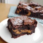 A rich, fudgy slice of Thermomix chocolate caramel brownie dusted with powdered sugar.