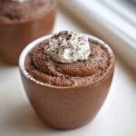 Close-up of a Thermomix Chocolate Mousse Cups topped with whipped cream and chocolate shavings.