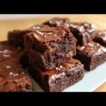 Close-up of fudgy Thermomix Mocha Walnut Butter Brownies stacked and sprinkled with sea salt.