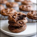 A stack of three rich, fudgy Bailey’s Irish Cream Cookies, with the top one broken open to show the soft interior.