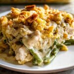 A close-up serving of Chicken and Stuffing Casserole featuring creamy sauce, shredded chicken, and bright green beans.