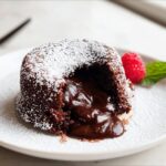 A single Chocolate Lava Cake for Two, dusted with powdered sugar, oozing rich molten chocolate.