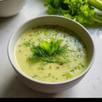 A close-up of creamy Celery Soup for Clean Eating, garnished with fresh dill and celery leaves.