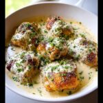 Five crispy, golden chicken thighs smothered in a rich, creamy garlic sauce and topped with fresh parsley.