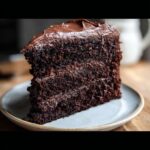 A rich, moist slice of Gluten-Free Dairy-Free Chocolate Cake with thick chocolate frosting.