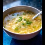 Close-up of a bowl of healthy Egg Drop Soup garnished with fresh green onions.