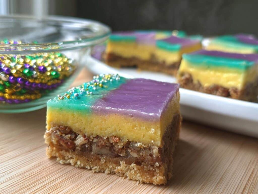 Close-up of a King Cake Inspired Dessert Bar showing pecan base and colorful purple and teal topping.