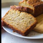 Close-up of a moist slice of Air Fryer Banana Bread with a golden-brown crust, served on a white plate.