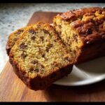 Close-up of a freshly baked loaf of Moist Cake Mix Banana Bread (3 Ingredients), sliced to show chocolate chips inside.