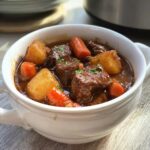 Close-up of a hearty Slow Cooker Stew with tender beef chunks, potatoes, and carrots in a rich brown gravy.