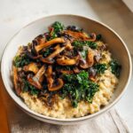 A bowl of creamy Savory Overnight Oats with Mushrooms and sautéed kale topping.