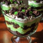 Close-up of a St. Patrick’s Day Brownie Trifle layered with green pudding, chocolate brownie pieces, and whipped cream.