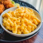 Close-up of a bowl filled with creamy, bright orange Gluten-Free Mac and Cheese made on the stovetop.