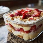 Layers of cream, vanilla pudding, strawberries, and graham crackers in a Strawberry Banana Pudding Dream.