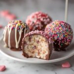 Close-up of a Valentine’s Day Lollipop Cake cut in half showing the cake center, surrounded by other decorated pops.